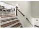 Staircase leading to a modern kitchen with stainless steel appliances and a granite island at 2227 Foley Park St, Snellville, GA 30078
