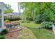 Spacious backyard with a stone patio, dining set, and beautiful landscaping for relaxing or entertaining guests at 3219 Parkridge Crescent, Chamblee, GA 30341
