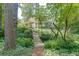 Tranquil backyard with a wooden bridge, mature trees, and a path leading to a charming home at 3219 Parkridge Crescent, Chamblee, GA 30341