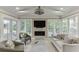 Bright sun room with a fireplace, large windows, vaulted ceilings with fan, and comfortable seating at 3219 Parkridge Crescent, Chamblee, GA 30341