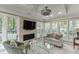 Inviting sun room features a fireplace, large windows with natural light, vaulted ceilings with a fan, and cozy decor at 3219 Parkridge Crescent, Chamblee, GA 30341