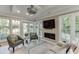 Bright sun room featuring a fireplace, large windows overlooking the greenery, and contemporary seating arrangement at 3219 Parkridge Crescent, Chamblee, GA 30341