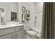 Well-lit bathroom with a white vanity, decorative mirrors, toilet, and a shower-tub combination at 402 Nix Ln, Lawrenceville, GA 30046