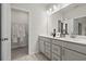 Bright bathroom with dual sink vanity, framed mirror, and a walk-in closet with shelving at 402 Nix Ln, Lawrenceville, GA 30046
