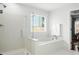 Bathroom featuring a walk-in shower and soaking tub by the window at 200 Ennisbrook Se Dr, Smyrna, GA 30082