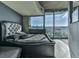 Bedroom featuring tufted headboard, cityscape views from balcony, and a stylish gray color palette at 361 17Th St # 1121, Atlanta, GA 30363