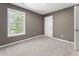 Inviting bedroom with a large window, fresh paint, and plush carpeting, creating a cozy and comfortable atmosphere at 429 Tannenhill Pl, Sugar Hill, GA 30518