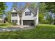 Beautifully landscaped home featuring green lawn, long driveway, and a two-car garage at 429 Tannenhill Pl, Sugar Hill, GA 30518