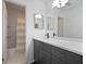 Modern bathroom with dark gray vanity, double mirrors, shower-tub combination and hexagonal tile floor at 5 Palace Green Place Nw, Atlanta, GA 30318