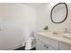 Bright white bathroom featuring modern fixtures, oval mirror, and black tile flooring at 5 Palace Green Place Nw, Atlanta, GA 30318