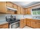 Well-lit kitchen featuring stainless steel oven, ample wood cabinetry and laminate flooring at 60 Cypress Dr, Covington, GA 30016