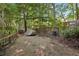 Gravel backyard space features a privacy fence, shed, and natural surroundings, providing a secluded outdoor area at 205 Pine Lake Dr, Cumming, GA 30040