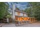 Rear exterior of home featuring large screened porch with seating, and stone patio at 205 Pine Lake Dr, Cumming, GA 30040