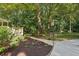 A beautiful backyard with green plants, a sidewalk and a lot of big trees creating a nature space at 205 Pine Lake Dr, Cumming, GA 30040