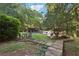 Landscaped backyard features a patio, pool, lush greenery, and mature trees, creating a serene outdoor oasis at 205 Pine Lake Dr, Cumming, GA 30040