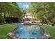 Inviting backyard pool with a waterfall, surrounded by lush greenery creating a private outdoor oasis at 205 Pine Lake Dr, Cumming, GA 30040