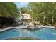Picturesque backyard featuring a lush lawn, serene pool area, and verdant trees, creating a peaceful outdoor oasis at 205 Pine Lake Dr, Cumming, GA 30040