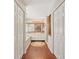 Hallway view of luxurious bathroom with double vanity, soaking tub, and two large linen closets at 205 Pine Lake Dr, Cumming, GA 30040