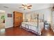 Cozy bedroom features hardwood floors, a ceiling fan, and a large wardrobe for ample storage at 205 Pine Lake Dr, Cumming, GA 30040