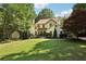Charming two-story home with a landscaped front yard and mature trees at 205 Pine Lake Dr, Cumming, GA 30040