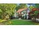 Inviting two-story home featuring a brick facade, lush landscaping, and a cozy covered entryway at 205 Pine Lake Dr, Cumming, GA 30040