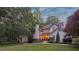 Charming, two-story home with a brick chimney and lush landscaping, all illuminated by warm light at 205 Pine Lake Dr, Cumming, GA 30040
