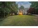 Charming, two-story home with a brick chimney, lush landscaping, and large front lawn at 205 Pine Lake Dr, Cumming, GA 30040