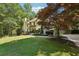 Well-manicured front lawn with shade tree, lush landscaping, and long driveway leading to the home at 205 Pine Lake Dr, Cumming, GA 30040