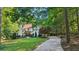 Charming two-story home with a well-manicured lawn, lush landscaping, and a welcoming driveway at 205 Pine Lake Dr, Cumming, GA 30040