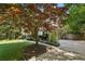 Two car garage with a long driveway and shade tree in a well-manicured lawn at 205 Pine Lake Dr, Cumming, GA 30040