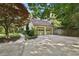Two car garage with a long driveway and lush landscaping in a wooded setting at 205 Pine Lake Dr, Cumming, GA 30040