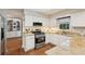 Kitchen features white cabinets, stainless steel appliances, and granite countertops at 205 Pine Lake Dr, Cumming, GA 30040