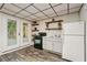 Basement kitchenette with stove, sink, refrigerator, and access to the outside via French doors at 205 Pine Lake Dr, Cumming, GA 30040
