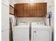 Functional laundry room with washer, dryer, and overhead storage cabinets at 205 Pine Lake Dr, Cumming, GA 30040