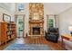 A living room featuring a stone fireplace, wood floors, a bookshelf, and large windows at 205 Pine Lake Dr, Cumming, GA 30040
