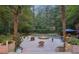 An outdoor living space with a large pool featuring a jacuzzi and a waterfall nestled among lush greenery and mature trees at 205 Pine Lake Dr, Cumming, GA 30040