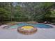 A gorgeous pool with a built-in jacuzzi with stone surround and multiple depths for swimming or relaxing at 205 Pine Lake Dr, Cumming, GA 30040