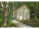 View of backyard shed with natural siding with double doors, windows, and a walkway at 205 Pine Lake Dr, Cumming, GA 30040