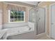 Bright bathroom with soaking tub, walk in shower, and a large window at 65 Pecan Ln, Oxford, GA 30054
