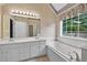 Well lit bathroom with double vanity, soaking tub, walk in shower and window at 65 Pecan Ln, Oxford, GA 30054