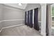 Neutral bedroom featuring a tray ceiling, large window and dark curtains at 65 Pecan Ln, Oxford, GA 30054