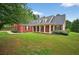 Attractive home with brick facade, black shutters, covered entry, and meticulously maintained lawn at 65 Pecan Ln, Oxford, GA 30054