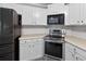 Updated kitchen features stainless steel oven, microwave, and refrigerator against white cabinets at 65 Pecan Ln, Oxford, GA 30054