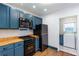 A galley kitchen offers blue cabinets, stainless appliances, and a view to laundry room at 958 Forrest Blvd, Decatur, GA 30030