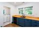 A bright kitchen features blue cabinetry, wood countertops and black hardware, plus view to laundry room at 958 Forrest Blvd, Decatur, GA 30030