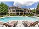 A refreshing backyard pool is surrounded by comfortable lounge chairs and lush landscaping at 170 Autry Trl, Johns Creek, GA 30022