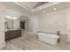 Stylish bathroom features a soaking tub, vanity with sink, and decorative mosaic tile wall at 170 Autry Trl, Johns Creek, GA 30022