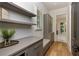 Inviting entryway with gray cabinets, floating shelves, drawers, and hardwood floors at 170 Autry Trl, Johns Creek, GA 30022