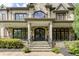 Close-up of the elegant stone front entrance with beautiful windows and custom ironwork at 170 Autry Trl, Johns Creek, GA 30022
