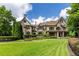 Stunning exterior view of this stone home showcasing its manicured lawn and beautiful architectural details at 170 Autry Trl, Johns Creek, GA 30022